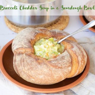 A plate with a Broccoli Cheddar Soup In A Sourdough Bowl.