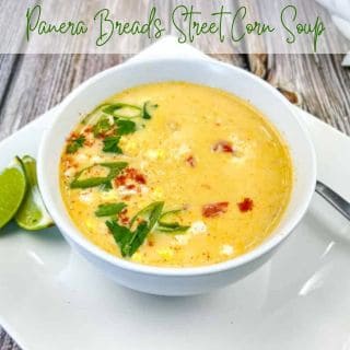 A plate with a bowl of Panera Bread’s Street Corn Soup and sliced lime.