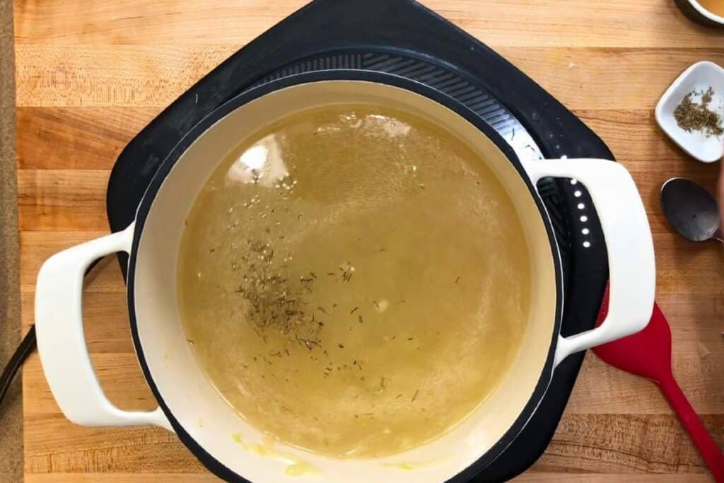 Whisk in the chicken stock, then add the salt, thyme, black pepper, and smoked paprika.